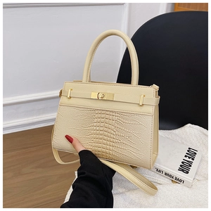 Close-up of beige crocodile pattern handbag with gold hardware and stylish handle
