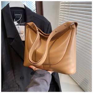 Close-up of the camel PU leather tote bag featuring wide shoulder straps and soft texture