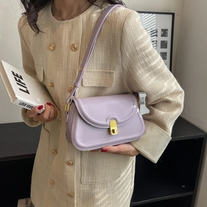Minimalist lavender shoulder bag with golden clasp on beige tweed outfit