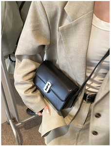 Close-up of black leather saddle bag with distinctive silver blade-shaped metal buckle