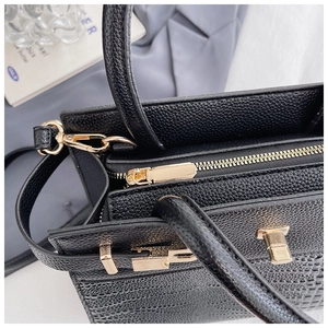 Top view of black leather handbag featuring gold hardware and elegant crocodile texture