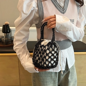 Detail shot of black woven net bag with a white drawstring liner in a home setting