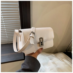 Detail of white leather saddle bag showing adjustable strap and silver metal buckle
