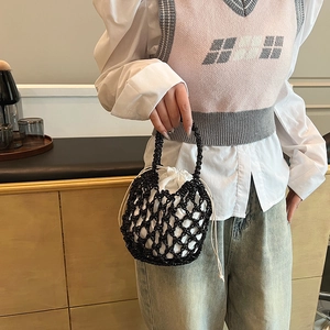 Detailed view of black beaded bucket bag featuring a white drawstring inner pouch liner