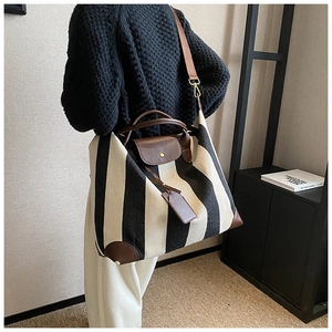 Détail d'un grand sac cabas à rayures noires et blanches avec poignées en cuir marron