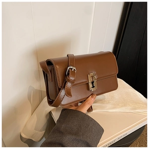 Brown leather saddle bag featuring a square silver metal clasp and adjustable strap