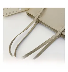 Détail des fines anses beiges et de la texture grainée de ce sac cabas en cuir