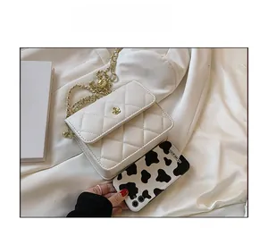 Mini white quilted crossbody bag size comparison with phone and golden chain strap detail