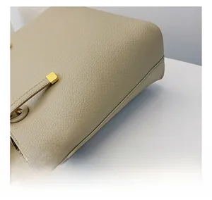 Détail des coutures en cuir grainé et finitions dorées sur ce sac cabas beige
