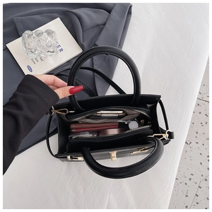 Internal view of black lychee grain handbag showing spacious compartments and metal zipper