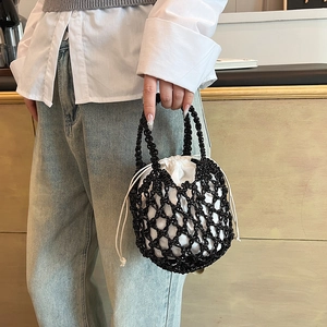 Detail of hand-woven bucket bag with black mesh exterior and white drawstring inner pouch