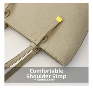 Détail du sac à bandoulière en cuir beige avec grain litchi et finitions dorées
