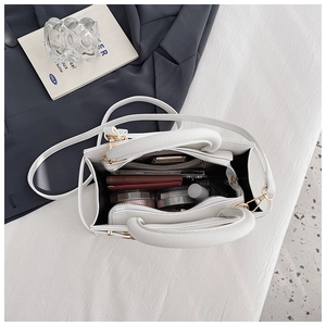Top view of white leather handbag interior showing storage for phone and wallet