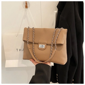 Detailed view of camel pleated crossbody bag featuring metal chain strap and twist lock