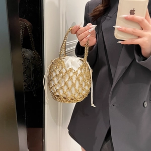 Detail of woven gold metal mesh bucket bag with a white drawstring inner pouch liner