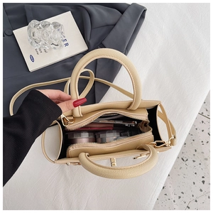 Top view of cream textured handbag showing spacious interior and golden hardware details