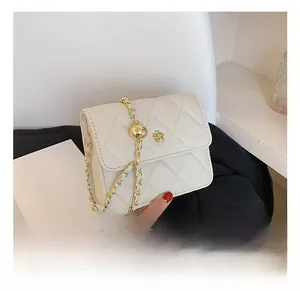 Close-up of beige quilted crossbody bag with gold chain and 3D floral accent