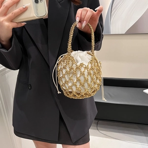 Close-up of golden hollow metal mesh bucket bag with white drawstring inner pouch