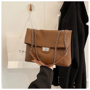 Close-up of the brown textured vertical stripe pattern and silver metal clasp on the bag