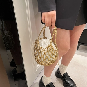 Detail of golden hollow-out woven bucket bag with white drawstring inner pouch