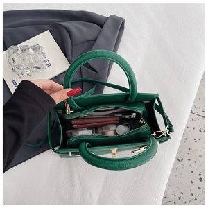 Detail view of green pebble texture tote bag with gold lock and spacious interior