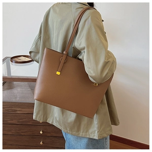 Gros plan du sac cabas marron en cuir grainé avec des détails métalliques dorés chic