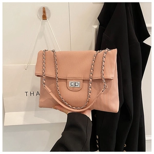 Detailed close-up of pink corduroy shoulder bag with silver chain and twist lock clasp