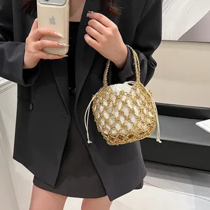 Detail of gold metal mesh woven bag with white drawstring inner pouch for women