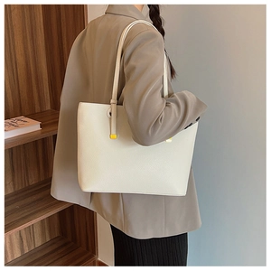 Détail du sac cabas blanc cassé avec texture grainée et accents métalliques dorés