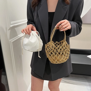 Front view of hollow knit golden tote with white drawstring pouch for beach vacations