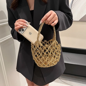 Close-up of golden hollow crochet mini tote bag showing size scale with a smartphone