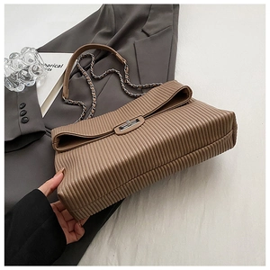 Macro view of brown pleated texture with silver metal clasp and chain strap on shoulder bag