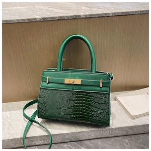 Close-up of dark green faux crocodile texture and gold clasp on a retro small square bag