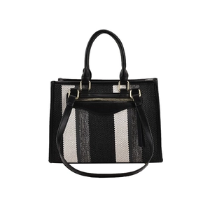 Striped canvas tote bag with black leather handles and spacious interior design