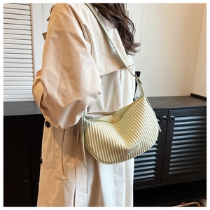 Detail of mint green pleated crescent bag with fashion label and zipper closure