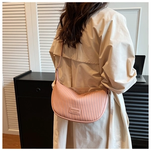 Detail of pink pleated crescent bag showing fine texture and fashion brand label on the side