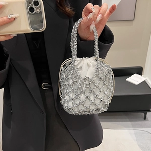 Detail of silver metallic mesh bucket bag with a white satin drawstring lining