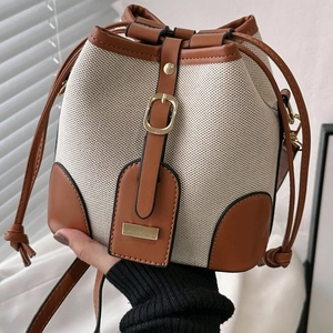 Contrast color canvas and brown leather bucket bag with elegant metal buckle detail