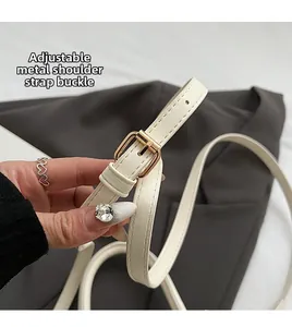 Detail of adjustable white leather shoulder strap with premium golden hardware buckle