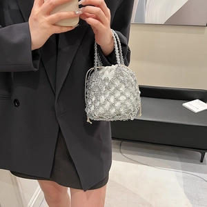 Close-up of silver hollow mesh woven bucket bag with white drawstring lining and handle