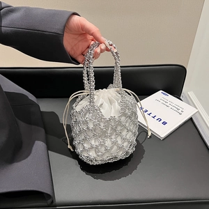 Detail of silver metallic woven mesh bucket bag with a white drawstring inner pouch