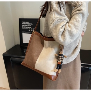 Detail of contrast color tote bag with matte texture and cute rabbit charm pendant