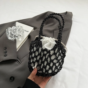 Detail of black woven bucket bag with white drawstring liner and mesh texture design