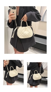 Detail of cream white quilted handbag with drawstring closure and chic round handle