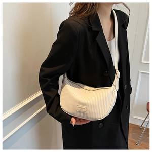 Detailed view of cream pleated crescent bag with fashion brand label and leather texture