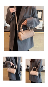 Detail of light beige pleated Boston bag with textured surface and silver hardware