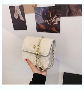 Detailed shot of quilted cream shoulder bag with gold floral clasp and adjustable ball chain