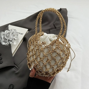 Detail of gold metal woven bucket bag with white drawstring liner on grey suit fabric