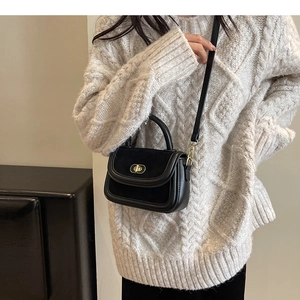 Sac à bandoulière vintage en velours noir avec fermoir doré sur pull en maille beige