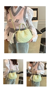Detail view of mint green quilted bucket bag with drawstring and gold hardware accents